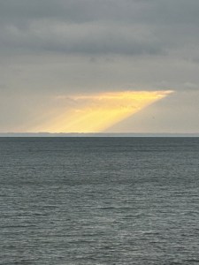 Sunlight through clouds slanting down to the lake